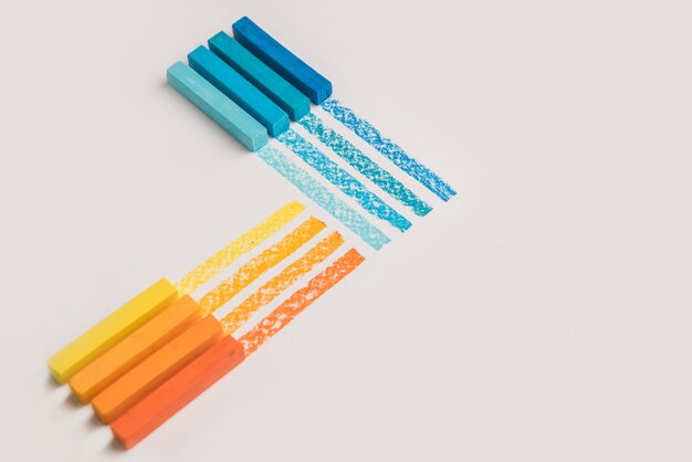 Cerca de tizas de crayón pastel de color sobre su propia línea de traza