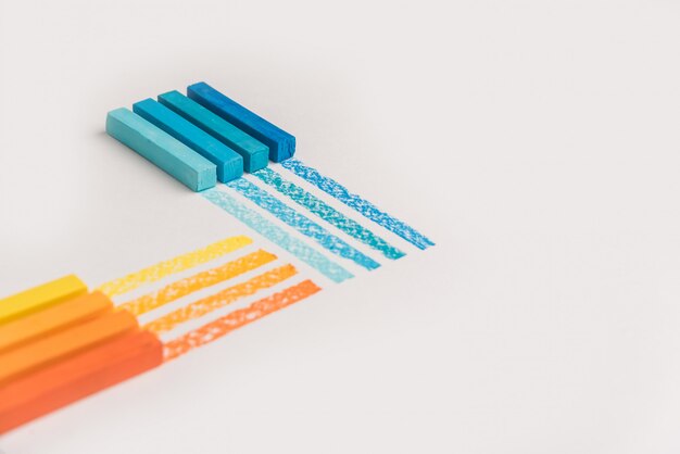 Cerca de tizas de crayón pastel de color sobre su propia línea de traza