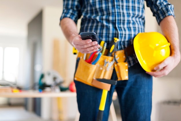 Cerca de trabajador de la construcción con teléfono móvil