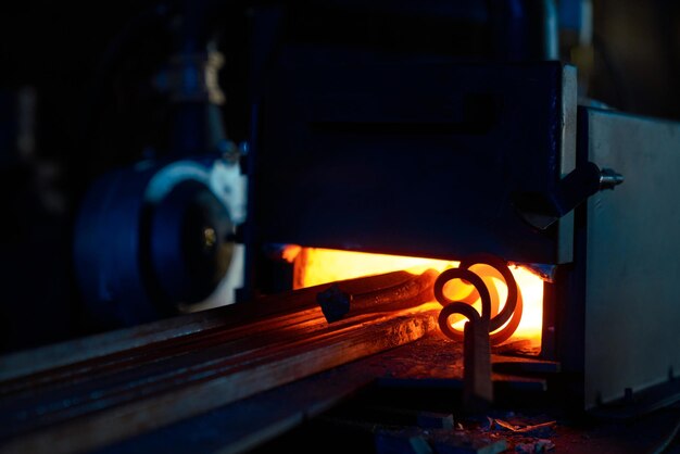 Cerca de varias piezas de calentamiento de hierro dentro del horno de forja Fuego ardiente con acero Preparación de metal para procesamiento