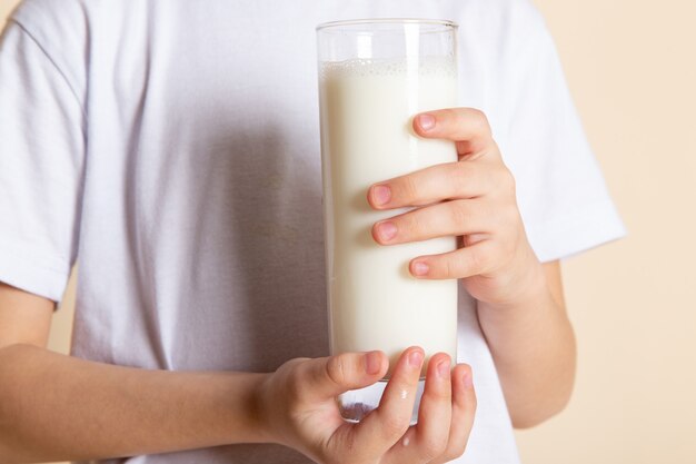 de cerca, ver niño pequeño con vaso de leche en t-shrit blanco