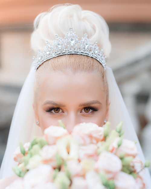 Foto gratuita cerca de la vista de una hermosa novia en una preciosa corona con un ramo en sus manos