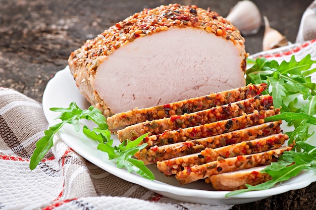 Cerdo al horno decorado con hojas de rúcula