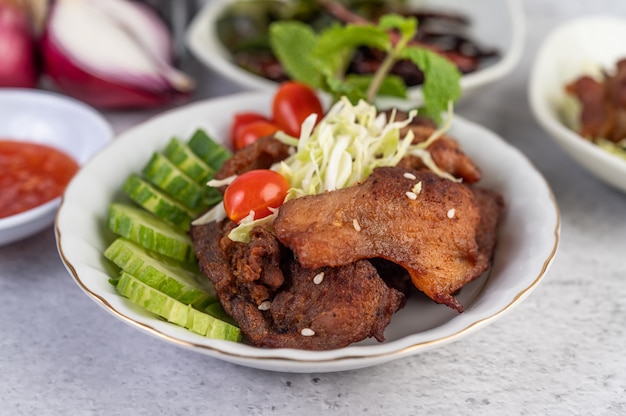 Cerdo frito cubierto con sésamo colocado en un plato blanco.