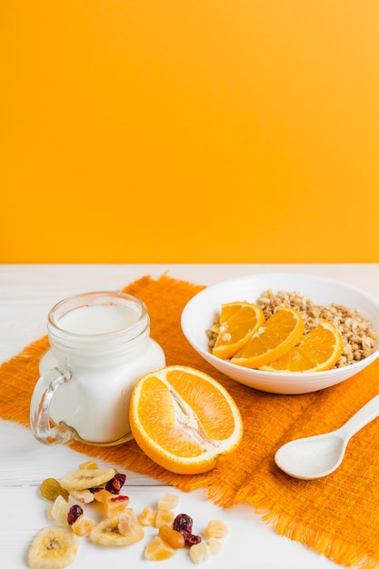 Foto gratuita cereal de alto ángulo con naranja y yogurt