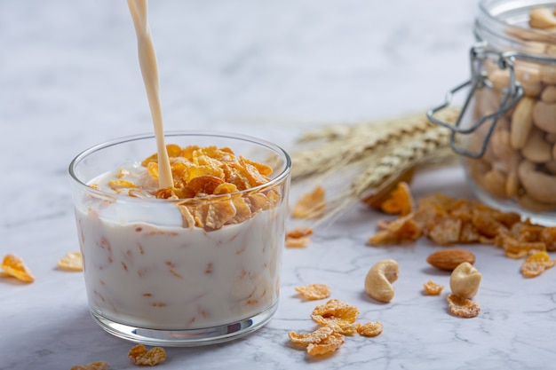 Cereal en un tazón y leche sobre fondo de mármol
