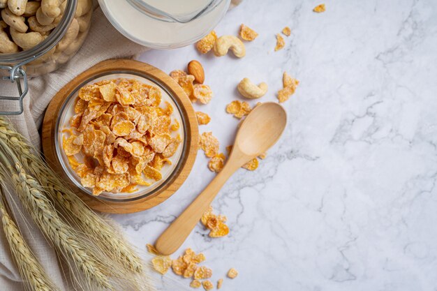 Cereal en un tazón y leche sobre fondo de mármol