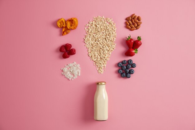 Cereales y varios ingredientes deliciosos para preparar el desayuno. Leche vegetal, avena, bayas y frutos secos para preparar deliciosas papillas en el desayuno. Estilo de vida saludable, nutrición, concepto de fitness