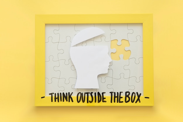 Cerebro humano abierto y marco de rompecabezas incompleto con mensaje de pensar fuera de la caja