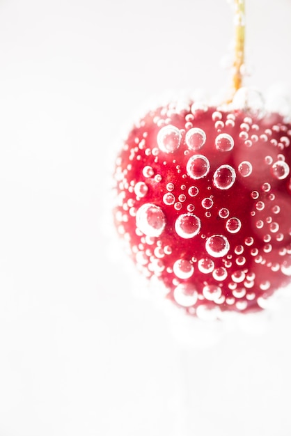 Cereza roja fresca madura del primer con agua