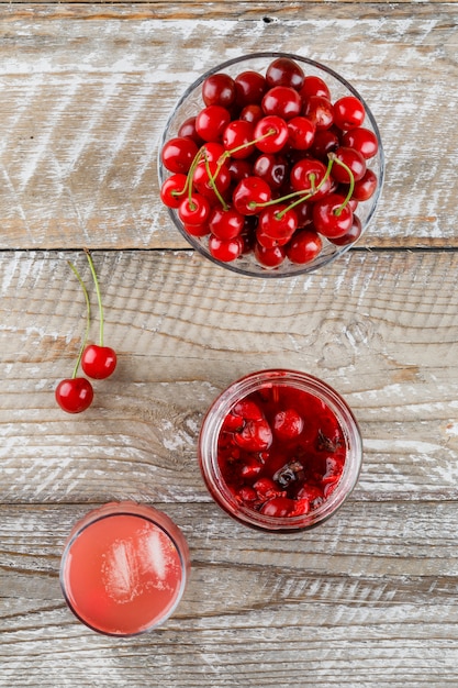 Cereza en un tazón con mermelada de cerezas, vista superior de cóctel en madera