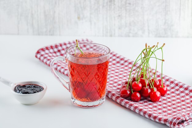 Cereza con té, mermelada, toalla de cocina, vista lateral