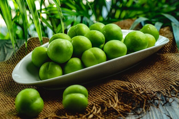 Cereza verde ciruela alycha en un plato blanco