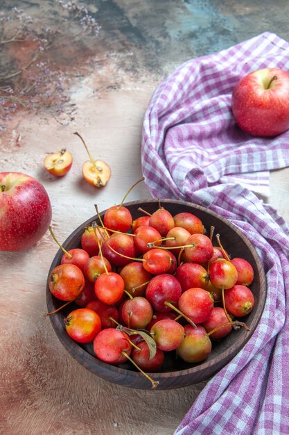 cerezas cerezas en el cuenco manzanas sobre el mantel a cuadros