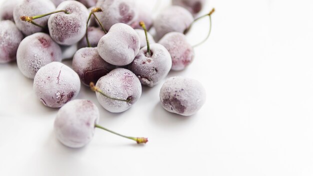 Cerezas congeladas sobre fondo blanco