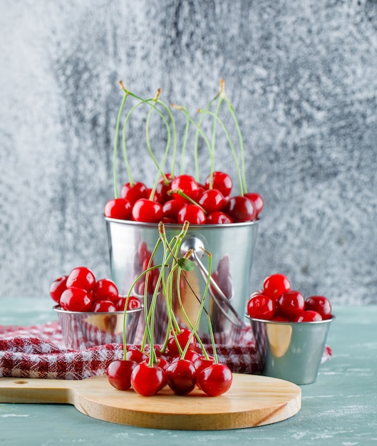 Cerezas en cubos con tabla de cortar, vista lateral de toalla de cocina