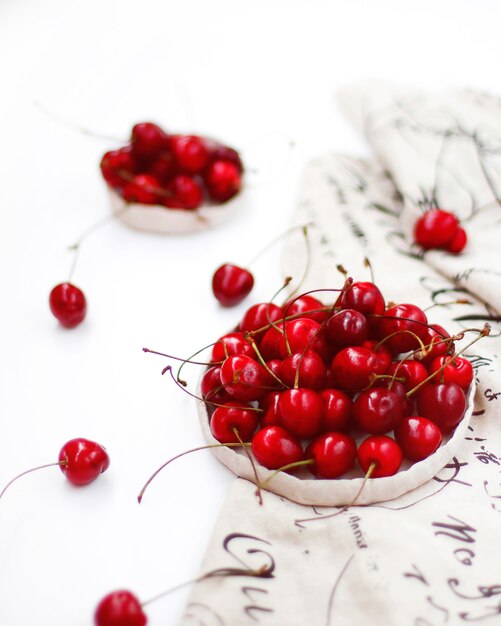 Cerezas en cuenco rústico de cerámica hecho a mano blanco.