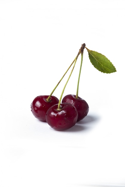 Cerezas rojas aisladas sobre fondo blanco