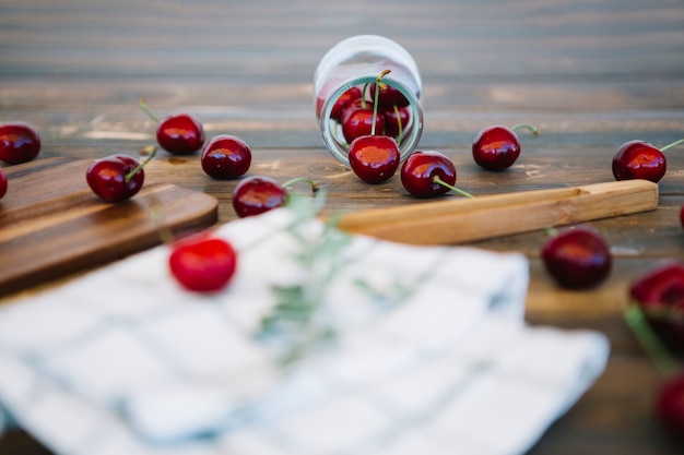 Foto gratuita cerezas rojas se derraman fuera del tarro