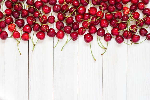 Foto gratuita cerezas rojas en madera blanca