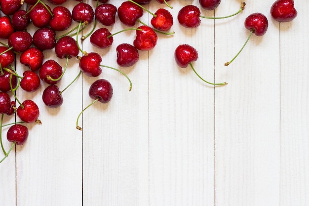 Foto gratuita cerezas rojas en madera blanca