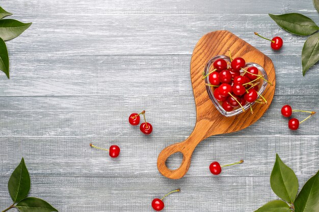 Cerezas rojas en plato tazón en mesa gris