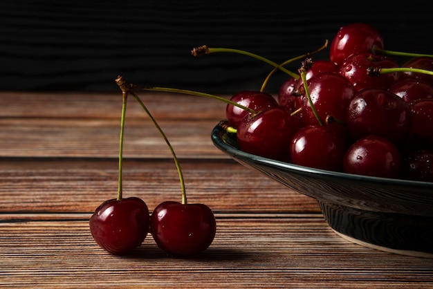 Foto gratuita cerezas rojas en un plato