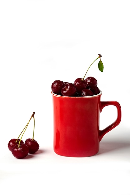 Cerezas rojas en una taza aislada