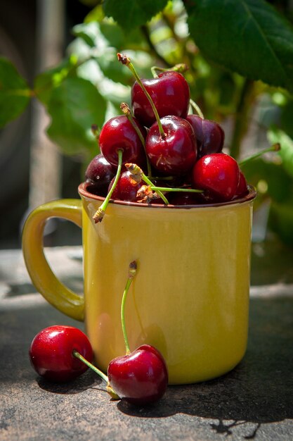 Cerezas en una taza amarilla