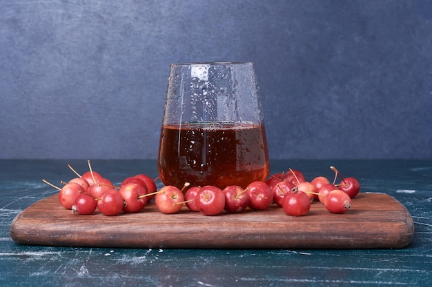 Cerezas con una taza de bebida en azul.