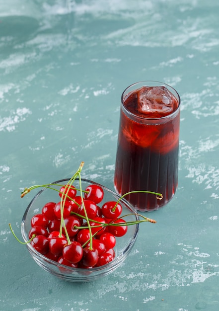 Cerezas en un tazón con vista de ángulo alto de jugo