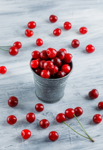 Foto gratuita cerezas en una vista de ángulo alto mini cubo en un grunge gris