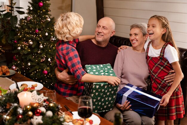 Cerrar los abuelos y los niños abriendo regalos