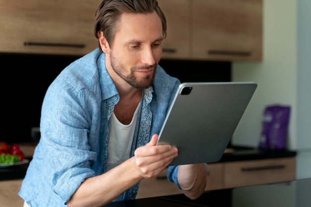 Cerrar al hombre usando un dispositivo digital en casa