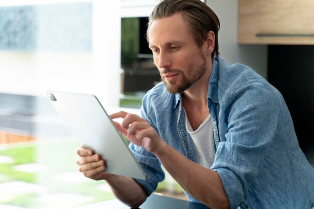 Cerrar al hombre usando un dispositivo digital en casa