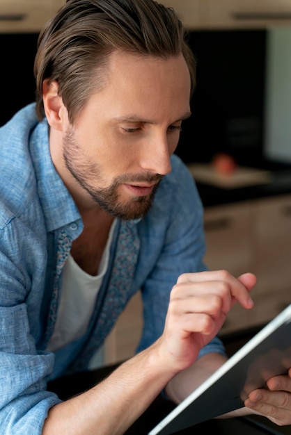 Cerrar al hombre usando un dispositivo digital en casa