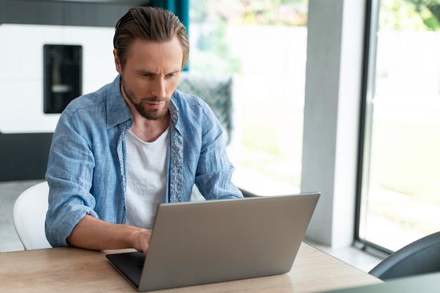 Cerrar al hombre usando un dispositivo digital en casa