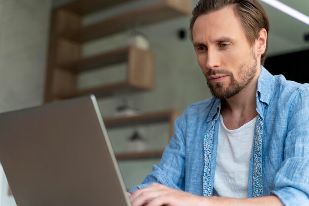 Cerrar al hombre usando un dispositivo digital en casa