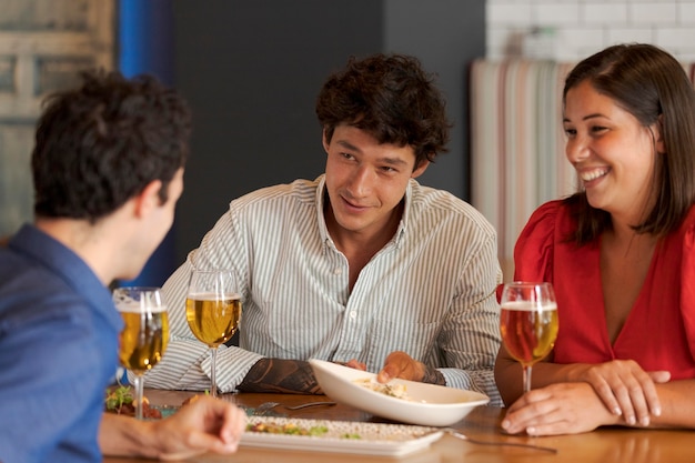 Cerrar amigos felices sentados en la mesa