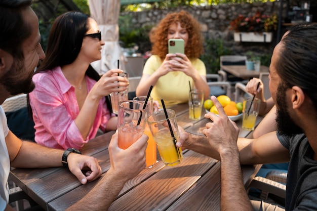 Cerrar amigos sentados a la mesa con bebidas