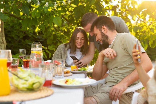 Cerrar amigos sentados a la mesa con comida