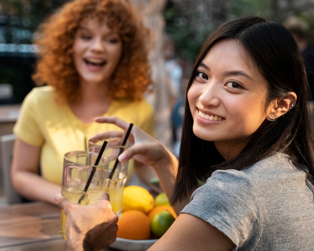 Foto gratuita cerrar amigos sonrientes con bebidas