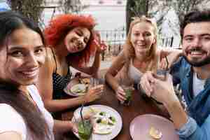 Foto gratuita cerrar amigos sonrientes con bebidas