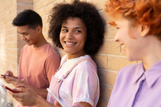 Cerrar amigos sonrientes con dispositivos