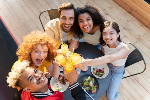 Foto gratuita cerrar amigos sonrientes sentados juntos