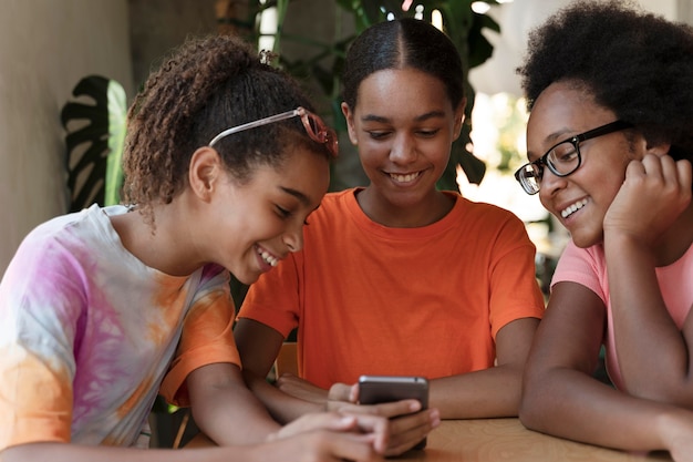 Cerrar amigos sonrientes con teléfono