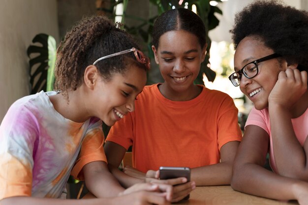 Cerrar amigos sonrientes con teléfono