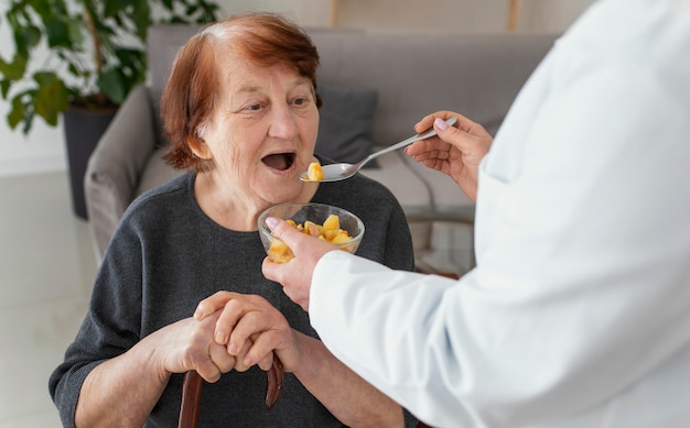 Foto gratuita cerrar anciana siendo alimentada