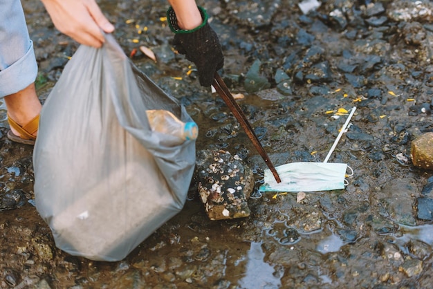 Cerrar la ayuda voluntaria para la conservación del medio ambiente para mantener y limpiar la basura de plástico y espuma en la playa y el área del parque Voluntariado día mundial del medio ambiente