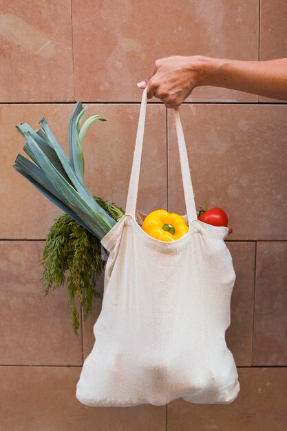Cerrar la bolsa de mano con verduras